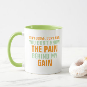SCHMERZEN UND ERWERBEN Orange und Grüner Text auf Tasse