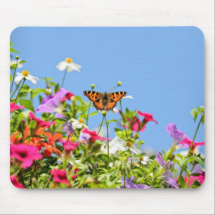 Schmetterling auf Blumen und blauem Himmel Mousepad