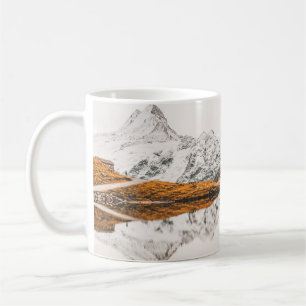 SCHNEEBEDECKTER FELLSENBERG UNTER BEWÖLKTEM HIMMEL KAFFEETASSE