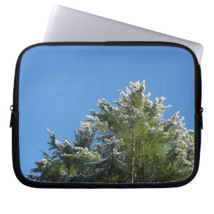Schneebedeckter Kiefernbaum auf blauem Himmel Laptopschutzhülle