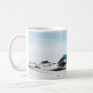 SCHNEEBEDECKTES LAND DURCH TAGESZEIT KAFFEETASSE