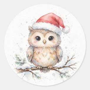 Schneeeule mit Weihnachtsmannmütze auf schneebedec Runder Aufkleber