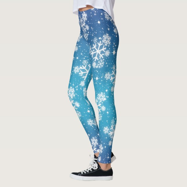 Schneeflocken und Sterne auf blass blauer Erde Leggings (Links)