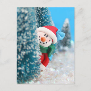 Schneemann versteckt oder pinkelt hinter einem Bau Postkarte