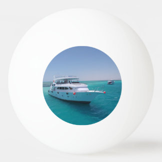 Schneeweiße Yacht in der Nähe der weißen Insel im  Tischtennisball
