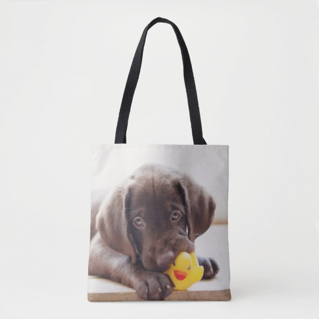Schokolade-Labrador-Welpe mit Spielzeugente Tasche (Vorderseite)