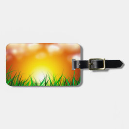 Schöner Sonnenaufgang über einem Grasfeld Gepäckanhänger