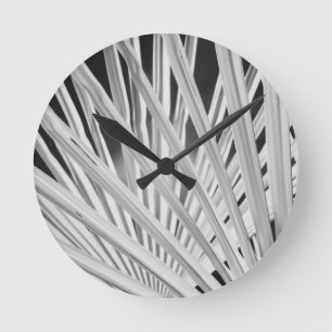 Schwarz-Weiß-Sicht auf Palmenfronten Runde Wanduhr
