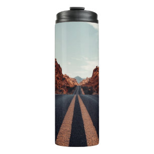 SCHWARZE ASPHALT-STRASSE ZWISCHEN BROWN ROCK FORMA THERMOSBECHER