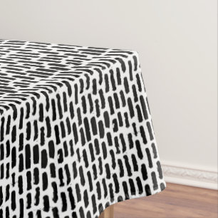 Schwarze Bürste streicht Muster Tischdecke