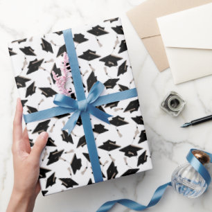 Schwarze Graduierungsklappen in der Luft auf Weiß Geschenkpapier