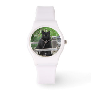 Schwarze Katze auf Brücke numerierter Uhr
