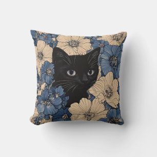 Schwarze Katze, die durch blaue und cremefarbene B Kissen