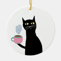 Schwarze Katze hält eine gemütliche Tasse