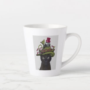 Schwarze Katze mit Teekanne und Schale Milchtasse