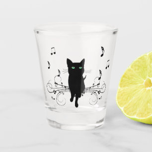 Schwarze Katze umgeben von flüsternden Noten der M Schnapsglas