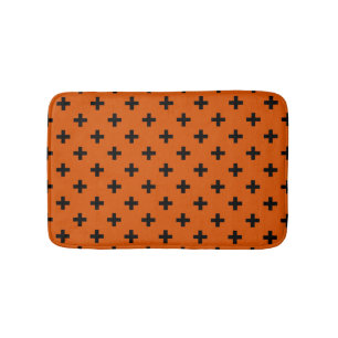 Schwarze Polka-Kreuze auf Orange Badematte