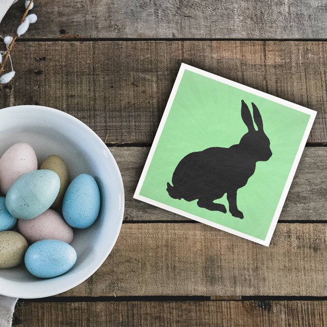 Schwarze Silhouette Form TallOhren auf Grün Serviette (Black sitting bunny rabbit on green paper napkin for spring or Easter.)