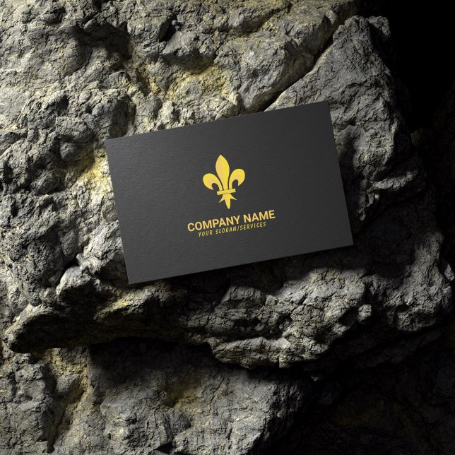 Schwarze Visitenkarte mit Gold-Lilie (Gold Fleur de Lis on Black Business Card lying on a rock)