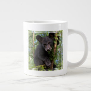 Schwarzer Bärenjunge spielt in Bäumen Jumbo-Tasse
