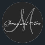 Schwarzer grauer Braut-Bräutigam des Monogramm-M Runder Aufkleber<br><div class="desc">Eleganter Hochzeitsaufkleber mit Monogramminitiale der Nachname- und Braut- und Bräutigamnamen, die Sie mit Ihrer persönlichen Information und Hochzeitsfarbentwurf besonders anfertigen können. Ein großer Aufkleber für Gastgeschenk Hochzeitsaufkleber, Tortenschachtel-Aufkleber-, weddingLeckereitasche Siegel- und weddingeinladungs-Umschlag Aufkleber. Entwurf durch Elke Clarke ©2008. Vor der Einrichtung verwenden Sie die Aufforderungen aber, wenn Sie den Buchstabegebrauch "ändern,...</div>