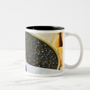 Schwarzer Kaviar und eine Löffel aus Perlmutt zum Zweifarbige Tasse