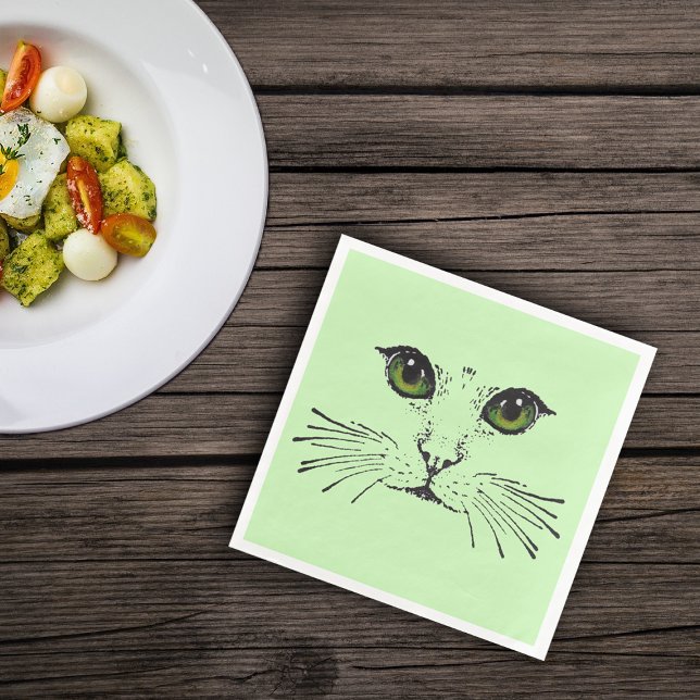 Schwarzes Aufschrecken des Gesichts von katzengrün Serviette (Cat face sketch in black with big green eyes and whiskers on light green paper napkins.)