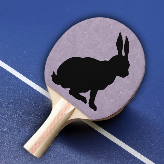 Schwarzes Kaninchen Silhouette Ostersonne Tischtennis Schläger (Black silhouette sitting rabbit on purple marble look background on ping pong paddle.)
