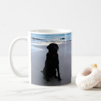 Schwarzes Labrador auf einem Strand Kaffeetasse