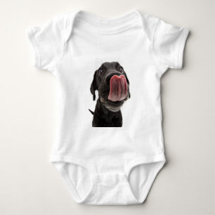 Schwarzes Labrador, das seine Nase leckt Baby Strampler