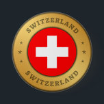 Schweizer Flagge Button<br><div class="desc">Die Schweizer Fahne ist in einen gerundeten Goldring der Imitate eingeprägt. Das Wort "Schweiz" steht ganz oben und unten im Design und hat einen gepressten Effekt. Das Paar von drei dekorativen Sternen zueinander,  sind auch mit einem gepressten Effekt gestaltet.</div>