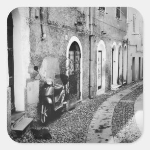 Scooter in einer Straße in Italien in Schwarz-Wei Quadratischer Aufkleber