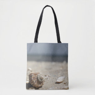 Seashells auf Sand durch das Meer Tasche