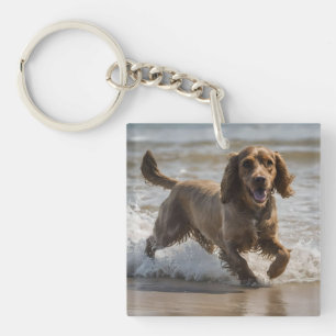 "Seaside Fun: Cocker Spaniel beim Spielen im Ozean Schlüsselanhänger