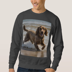 "Seaside Fun: Cocker Spaniel beim Spielen im Ozean Sweatshirt
