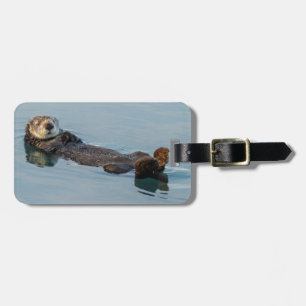 Seeotter schwimmt auf dem Rücken im Ozean Gepäckanhänger