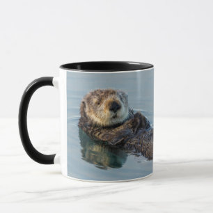 Seeotter schwimmt auf dem Rücken im Ozean Tasse