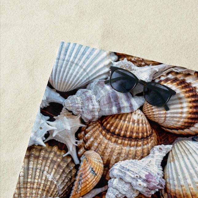 Serviette de plage Sea Shells (A vibrant collection of seashells scattered across a sandy surface. )