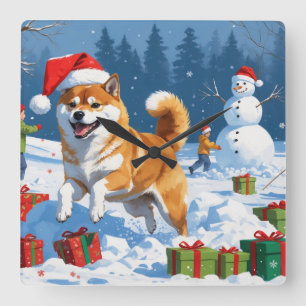 Shiba Inu läuft im Schnee mit Weihnachtsmütze Quadratische Wanduhr