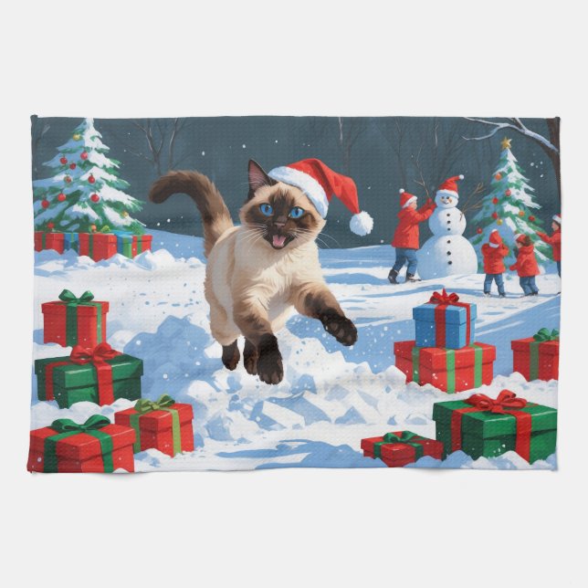 Siamische Katze läuft im Schnee mit Weihnachtsmütz Geschirrtuch (Horizontal)