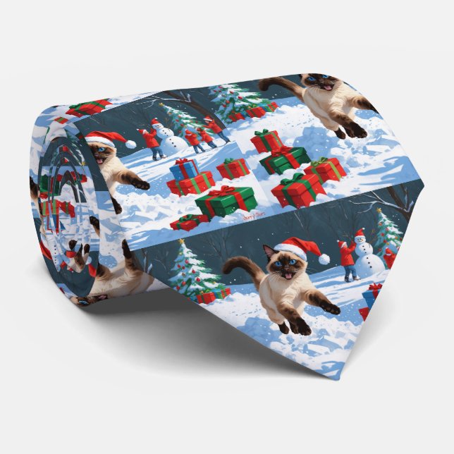 Siamische Katze läuft im Schnee mit Weihnachtsmütz Krawatte (Gerollt)