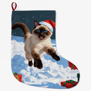 Siamkatze läuft im Schnee mit Weihnachtsmütze Großer Weihnachtsstrumpf