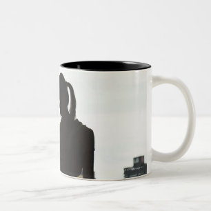 Silhouette der anhebenden Gewichte der Frau an der Zweifarbige Tasse