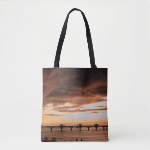 SILHOUETTE DER MENSCHEN AM STRAND WÄHREND DES SONN TASCHE