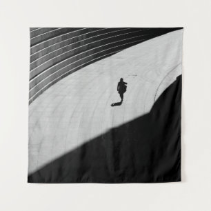 SILHOUETTE EINER PERSON, DIE AUF DER GRAUEN KONKRE WANDTEPPICH