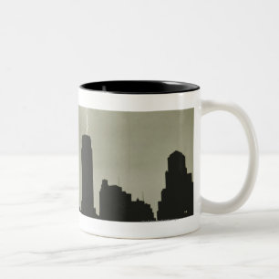 Silhouetten der Wolkenkratzer und des Blitzes im Zweifarbige Tasse