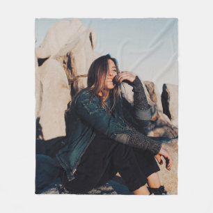 Sitting and smiling woman wearing black pants fleecedecke