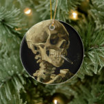 Skelett mit brennender Zigarette | Vincent van Gog Keramik Ornament<br><div class="desc">Der Schädel eines Skeletts mit brennender Zigarette (1886) von Vincent van Gogh ist ein auffälliges und unkonventionelles Stillleben-Gemälde mit einem menschlichen Schädel mit einer beleuchteten Zigarette zwischen den Zähnen. Der dunkle Hintergrund verstärkt die Krassigkeit der Skelettfigur, während die kleine Rauchwolke ein Gefühl von Durchgängigkeit und Ironie verleiht. Dieses Kunstwerk, das...</div>