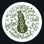 Snowman Christmas Winter Wonderland Typografie Runder Aufkleber<br><div class="desc">Eine festliche typografische Komposition von handgeschriebenem Weihnachtszitat (Schneekill, Steinglocken, Kalter Winter, Weiße Weihnachten, Wunderland, Weihnachtswunsch) umkreist einen Schneemann mit kleinen Herzen und Schneeflocken. Ideal, um Weihnachts- und Feiertagsbriefe und Weihnachtskarten zu Siegel oder Ihre Geschenke unter dem Weihnachtsbaum zu schmücken! Forest Green Farbe ist vollständig veränderbar, auch die Farbe Weiß ist...</div>