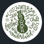Snowman Christmas Winter Wonderland Typografie Runder Aufkleber<br><div class="desc">Eine festliche typografische Komposition von handgeschriebenem Weihnachtszitat (Schneekill, Steinglocken, Kalter Winter, Weiße Weihnachten, Wunderland, Weihnachtswunsch) umkreist einen Schneemann mit kleinen Herzen und Schneeflocken. Ideal, um Weihnachts- und Feiertagsbriefe und Weihnachtskarten zu Siegel oder Ihre Geschenke unter dem Weihnachtsbaum zu schmücken! Forest Green Farbe ist vollständig veränderbar, auch die Farbe Weiß ist...</div>